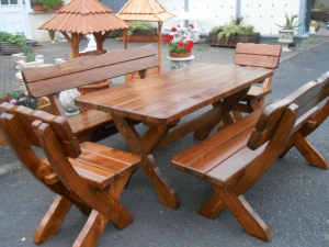 Rustikale Gartengarnitur aus massivem Holz mit Tisch, zwei Bänken und zwei Stühlen auf einem asphaltierten Platz, ideal für Garten oder Terrasse.
