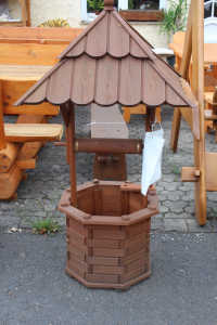 Rustikaler Holzbrunnen mit Spitzdach, ideal als dekorativer Blickfang oder Pflanzkübel im Garten.