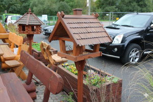 Holz-Vogelhaus mit wetterfestem Schindeldach auf Ständer – rustikales Design für Garten oder Terrasse.